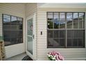 Front door with glass and storm door and nearby windows at 579 Juniper Way, Tavares, FL 32778
