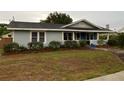 Charming single story home with light blue siding and well-manicured landscaping around the front at 604 N Old Wire Rd, Wildwood, FL 34785