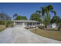 Inviting single-story home with a long driveway, well-maintained lawn, and appealing landscaping at 616 Third Ave, Lady Lake, FL 32159