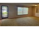 Bright living room featuring a large window, neutral walls, and built-in shelving at 619 W Seminole Ave, Eustis, FL 32726