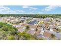 Aerial view of a quiet residential neighborhood with well-maintained homes and lush green trees at 704 Chelsea Ave, Fruitland Park, FL 34731