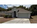 Charming single-story home with neutral paint, arched entryway, and a spacious two-car garage at 704 Chelsea Ave, Fruitland Park, FL 34731