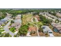 Aerial view of a community home backing onto a lush green golf course with pond at 705 Grand Vista Trl, Leesburg, FL 34748