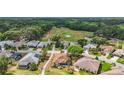 An aerial view of a home in a well-maintained community with a nearby golf course and tree lined streets at 705 Grand Vista Trl, Leesburg, FL 34748