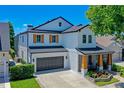 Beautiful two-story home with a dark gray garage door, wood-accented porch columns, and manicured landscaping at 722 Barefoot Bay Loop, Clermont, FL 34736