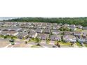 Sprawling aerial view showcasing a neighborhood filled with modern homes and lush greenery and a glimpse of the lake at 743 Brooks Field Drive Dr, Winter Garden, FL 34787