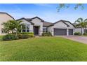 Charming single-story home boasting a lush green lawn, brick driveway, and a convenient two-car garage at 743 Brooks Field Drive Dr, Winter Garden, FL 34787