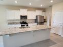 Modern kitchen with stainless steel appliances, granite countertops and large island at 7974 Penrose Pl, Wildwood, FL 34785