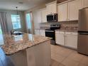 Well-equipped kitchen with granite countertops, stainless appliances and ample storage at 7974 Penrose Pl, Wildwood, FL 34785