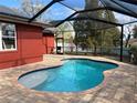 Inviting screened-in pool area with brick pavers and serene outdoor setting at 808 Chamberlain Loop, Lake Wales, FL 33853