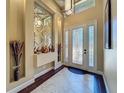 Light-filled foyer with decorative mirror, tile flooring, and elegant front door at 8387 Bridgeport Bay Cir, Mount Dora, FL 32757