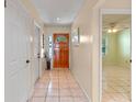 Light and bright foyer with tile floors and a charming wooden front door at 903 Belle Oak Dr, Leesburg, FL 34748