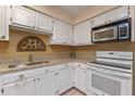 Bright kitchen with white cabinets, granite countertops, and modern appliances at 903 Belle Oak Dr, Leesburg, FL 34748