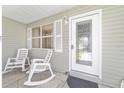 Close-up of the welcoming front porch with a decorative door and comfortable rocking chairs, creating a cozy entrance at 923 Oleander St, The Villages, FL 32159