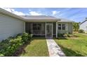 Inviting screened front porch with stone pavers and two comfortable rocking chairs, perfect for relaxing at 923 Oleander St, The Villages, FL 32159