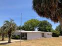 Low-angle shot of a well-maintained single story home and lush green lawn at 1030 Vermont Ave, Lady Lake, FL 32159