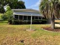 Charming single-story home featuring a well-maintained lawn and a mature palm tree at 1030 Vermont Ave, Lady Lake, FL 32159