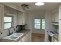 Bright kitchen with white cabinets, tile countertops, and a view into the dining area at 1030 Vermont Ave, Lady Lake, FL 32159