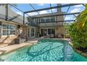 A beautiful screened in pool with crystal clear water sits adjacent to a stone-clad home at 111 Kentucky Blue Cir, Apopka, FL 32712
