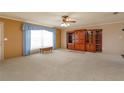 Expansive living room features a large window, cozy carpet, and a built-in wooden cabinet at 1110 Fairfax St, Leesburg, FL 34748