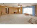 Large living area featuring plush carpeting, a large window and an open entryway to other rooms at 1110 Fairfax St, Leesburg, FL 34748