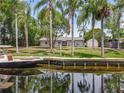 Beautiful backyard with a wood dock, boat and lush tropical landscaping at 11114 Lake Eustis Dr, Leesburg, FL 34788