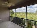Relaxing screened balcony with ceiling fan offering lush, private views of the nature preserve at 1288 Grady Ln, Davenport, FL 33896