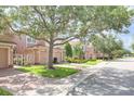 A long line of peach colored two-story townhomes are viewed from the street on a sunny day at 1288 Grady Ln, Davenport, FL 33896