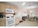Cozy kitchen with white appliances, white cabinetry and a breakfast nook at 1318 Guerra Ave, The Villages, FL 32159