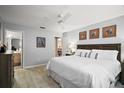 Comfortable main bedroom with a large bed, ceiling fan, wood floors and ensuite bathroom at 1318 Guerra Ave, The Villages, FL 32159