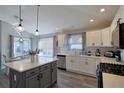 Modern kitchen featuring an island with seating, white cabinets, and stainless steel appliances at 1451 Rosedale Way, The Villages, FL 32162
