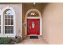 Inviting front entrance with a bright red door, decorative sidelights, and neutral tile flooring at 14624 Pine Lake St, Clermont, FL 34711