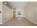 Bright living room with tile floors, neutral walls, and arched windows with views of the front yard at 14624 Pine Lake St, Clermont, FL 34711