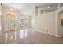 Spacious open-plan living area featuring tile floors, high ceilings, and elegant chandelier lighting at 14624 Pine Lake St, Clermont, FL 34711