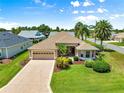 Charming single-story home with a well-maintained lawn, attached garage, and lush palm trees at 1723 Townsend Ter, The Villages, FL 32162