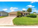 Inviting single-story home with a manicured lawn, a two-car garage, and verdant landscaping at 1723 Townsend Ter, The Villages, FL 32162