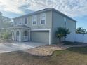 View of home featuring an attached two-car garage, a well-manicured lawn, and minimal landscaping at 1730 Ridgemoor Dr, Mascotte, FL 34753