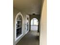 Covered porch featuring white accents, arched windows, and views of the outdoors at 1730 Ridgemoor Dr, Mascotte, FL 34753