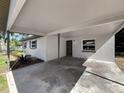 Exterior shot showcasing a covered carport with painted brick and concrete flooring leading to the front door at 1905 Selleen Dr, Eustis, FL 32726