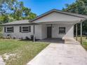 Inviting home exterior with a carport, manicured lawn, and garden beds, offering a blend of comfort and curb appeal at 1905 Selleen Dr, Eustis, FL 32726