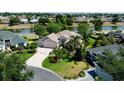 Aerial view of a single-Gathering home situated on a large lot with lush landscaping near a pond at 2237 Avon Loop, The Villages, FL 32162