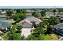 Aerial view of a single-Gathering home with a paver driveway, a two-car garage, and views of the pond at 2237 Avon Loop, The Villages, FL 32162