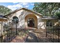 Stunning front exterior of the home with gated courtyard and arched entryway at 27011 Se Highway 42, Umatilla, FL 32784