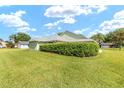 Expansive backyard featuring lush lawn and mature hedges providing privacy at 2750 Coral Reef Way, Tavares, FL 32778