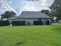 View of a spacious backyard featuring a well-maintained lawn and mature hedges bordering the property at 2750 Coral Reef Way, Tavares, FL 32778