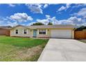 Inviting single-story home with a well-kept lawn, a driveway, and an attached two-car garage at 2833 Beal St, Deltona, FL 32738