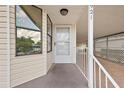 Inviting front porch with white railing and access to the carport and front door at 2921 Wekiva Rd, Tavares, FL 32778