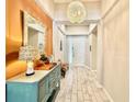 Bright entryway featuring neutral walls, light wood-look tile flooring, and decorative chandelier at 31857 Dahlia Ct, Eustis, FL 32736