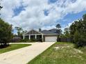 Charming single-Gathering home featuring a large driveway, two-car garage, and landscaped front yard at 31857 Dahlia Ct, Eustis, FL 32736