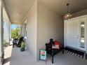 Inviting front porch decorated with a bench, pillows, and a welcoming sign at 31857 Dahlia Ct, Eustis, FL 32736